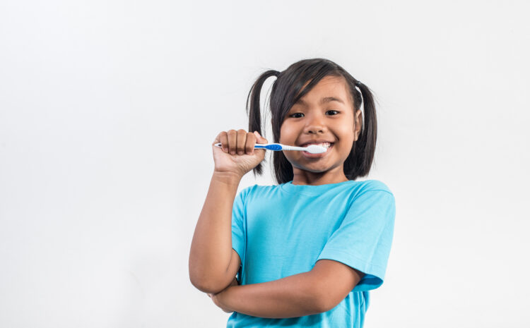 little girl brushing her teeth in studio shot